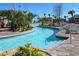 A winding lazy river style pool lined with palm trees and lounge chairs on a sunny day at 1555 Flange Dr, Davenport, FL 33896