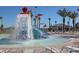 A colorful splash pad with a waterslide, dumping bucket, and lounge chairs on a sunny day at 1555 Flange Dr, Davenport, FL 33896