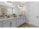 Bright bathroom featuring double vanities, granite countertops, and a large framed mirror with great lighting at 16089 Parkwyn St, Winter Garden, FL 34787