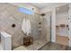 Bathroom featuring a glass enclosed shower, and a wooden bench seat, all with neutral tile at 16089 Parkwyn St, Winter Garden, FL 34787