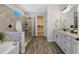 Bathroom featuring glass shower, soaking tub, granite countertops, double sinks, and tile flooring at 16089 Parkwyn St, Winter Garden, FL 34787