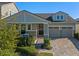 Charming exterior view of home featuring a 2-car garage, inviting front door, and professionally landscaped yard at 16089 Parkwyn St, Winter Garden, FL 34787