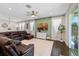 Cozy living room featuring a decorative green accent wall, neutral curtains, and sliding glass doors at 16089 Parkwyn St, Winter Garden, FL 34787