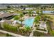 Aerial view of a large community pool area with lounge chairs, palm trees, and nearby clubhouse at 16089 Parkwyn St, Winter Garden, FL 34787