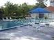 Pool view with a blue umbrella, lounge chairs and nice landscaping at 162 Lago Vista Blvd, Casselberry, FL 32707