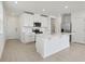 Bright, open kitchen with white cabinets, stainless steel appliances and a large center island at 16450 Bird Of Paradise Ave, Clermont, FL 34714