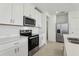 Well-lit kitchen with stainless steel appliances, quartz countertops and white cabinets at 16450 Bird Of Paradise Ave, Clermont, FL 34714