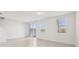 Bright, open-plan living room featuring tile flooring, sliding glass door, and large windows allowing ample natural light at 16450 Bird Of Paradise Ave, Clermont, FL 34714