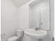 Cozy powder room featuring pedestal sink, white toilet and neutral paint at 16450 Bird Of Paradise Ave, Clermont, FL 34714