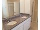 Bathroom vanity featuring double sinks, granite countertops, white cabinets, and a large mirror at 16749 Harper Cove Dr, Winter Garden, FL 34787