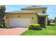 Charming two-story home features a two-car garage, brick driveway, manicured lawn, and inviting exterior design at 16749 Harper Cove Dr, Winter Garden, FL 34787