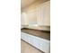 Kitchen counter space with granite countertops, white cabinets, tile flooring, and a window at 16749 Harper Cove Dr, Winter Garden, FL 34787