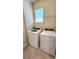 Functional laundry room with modern washer and dryer, tile flooring, and overhead shelving at 16749 Harper Cove Dr, Winter Garden, FL 34787