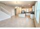 Spacious open-concept living area with tile flooring, staircase, and bright natural light at 16749 Harper Cove Dr, Winter Garden, FL 34787