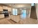 Open concept living space featuring tile flooring, white cabinets, stainless steel appliances, and staircase at 16749 Harper Cove Dr, Winter Garden, FL 34787