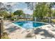 Community pool surrounded by trees and a black metal fence, offering residents a refreshing escape at 1709 Winter Green Blvd, Winter Park, FL 32792