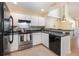 Efficient kitchen features a stainless steel stove, white cabinetry, and a breakfast bar at 1709 Winter Green Blvd, Winter Park, FL 32792