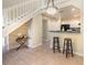 Open-concept living area with bar seating, tiled floor, and adjacent staircase at 1709 Winter Green Blvd, Winter Park, FL 32792