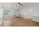 Well-lit living room with wood flooring, neutral gray walls, a vaulted ceiling with a ceiling fan, and a large window at 1811 Oakgrove Ave, Deltona, FL 32725