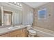 Bright bathroom featuring a tub with tiled shower, vanity, and toilet with neutral-toned walls at 2005 E Grant Ave, Orlando, FL 32806