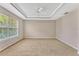 Bedroom with a tray ceiling, a ceiling fan, and neutral carpeting at 2005 E Grant Ave, Orlando, FL 32806