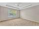 Bright bedroom with a tray ceiling, a ceiling fan, and neutral carpeting at 2005 E Grant Ave, Orlando, FL 32806