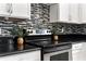Close up of a modern kitchen featuring stainless steel range, granite countertops, and tiled backsplash at 2005 E Grant Ave, Orlando, FL 32806