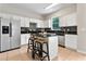 Bright kitchen boasts white cabinets, a central island with seating, and modern appliances at 2005 E Grant Ave, Orlando, FL 32806