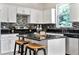 Well-lit kitchen features a center island with stools, granite countertops, and mosaic backsplash at 2005 E Grant Ave, Orlando, FL 32806