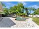 Backyard view with a uniquely shaped pool, stone walkway, and lush tropical landscaping at 2005 E Grant Ave, Orlando, FL 32806