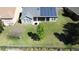 Aerial shot of a home with a manicured lawn, solar panels, and a screened lanai at 228 Bayou Bend Rd, Groveland, FL 34736