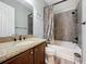 Bathroom featuring a granite vanity, shower, tub with curtain and commode at 228 Bayou Bend Rd, Groveland, FL 34736