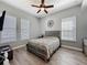 A cozy bedroom with a ceiling fan and two windows showing wood-look flooring at 228 Bayou Bend Rd, Groveland, FL 34736