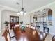 Bright dining room features a dark wood table with an elegant chandelier and easy kitchen access at 228 Bayou Bend Rd, Groveland, FL 34736