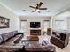 Comfortable living room features a plush leather sectional, ceiling fan, and large television at 228 Bayou Bend Rd, Groveland, FL 34736