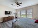 Well-lit main bedroom features a ceiling fan, and backyard views from the windows at 228 Bayou Bend Rd, Groveland, FL 34736