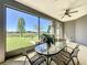 This screened-in patio features a table and chairs and views of the backyard at 228 Bayou Bend Rd, Groveland, FL 34736