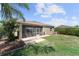 Exterior view of a home with a screened-in porch and patio in the fenced backyard at 2319 Grantham Ave, Davenport, FL 33837