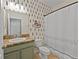 Stylish bathroom featuring graphic wallpaper and a shower with a decorative curtain at 2319 Grantham Ave, Davenport, FL 33837