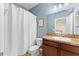 Bright bathroom with a white shower curtain, vanity with granite top, and a framed nautical print above the toilet at 2319 Grantham Ave, Davenport, FL 33837