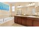 Bright bathroom features a soaking tub, double vanity, and elegant fixtures at 2319 Grantham Ave, Davenport, FL 33837