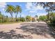 Community entrance with a security gate, mature trees, lush landscaping, and a brick paved road at 2319 Grantham Ave, Davenport, FL 33837