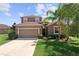 Inviting home featuring lush landscaping, a two-car garage, and a covered entrance for added curb appeal at 2319 Grantham Ave, Davenport, FL 33837