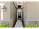 Close-up of the inviting front door, flanked by stone accents and lush greenery, adding a touch of elegance at 2319 Grantham Ave, Davenport, FL 33837