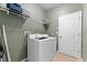 Laundry room featuring a front load washer and dryer with storage shelves above at 2319 Grantham Ave, Davenport, FL 33837