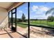 Screened patio with stone floor, a chair, and a view of a manicured lawn and green space at 2319 Grantham Ave, Davenport, FL 33837