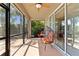 Screened porch with egg chairs, orange cushions, and views of lush palm trees and tropical landscaping at 2319 Grantham Ave, Davenport, FL 33837