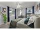 This bedroom features abundant light, a ceiling fan, modern decor, and stylish blue curtains at 2429 Yale Ave, Sanford, FL 32771