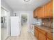 Functional kitchen with wood cabinets and white appliances, adjacent to dining area and bonus room at 2429 Yale Ave, Sanford, FL 32771