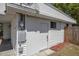 Rear exterior view of a well maintained white house featuring a side entrance, utility access and fence at 2429 Yale Ave, Sanford, FL 32771